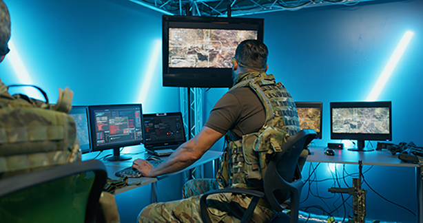Soldier sitting in control room looking at a computer screen